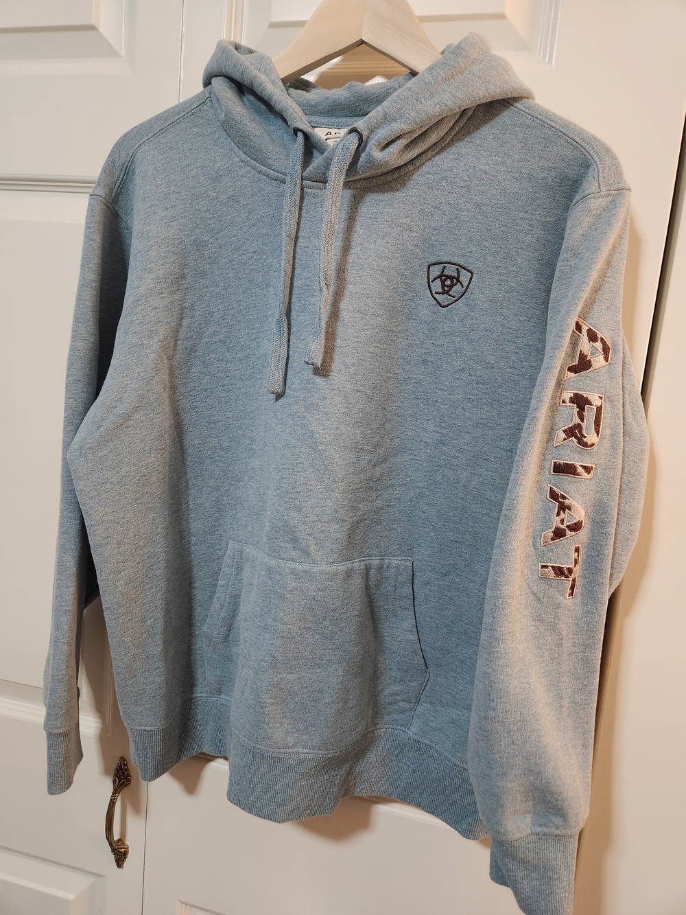 Ariat Womens Light Blue Hoodie with Cow Print Embroidered Sleeve Logo.